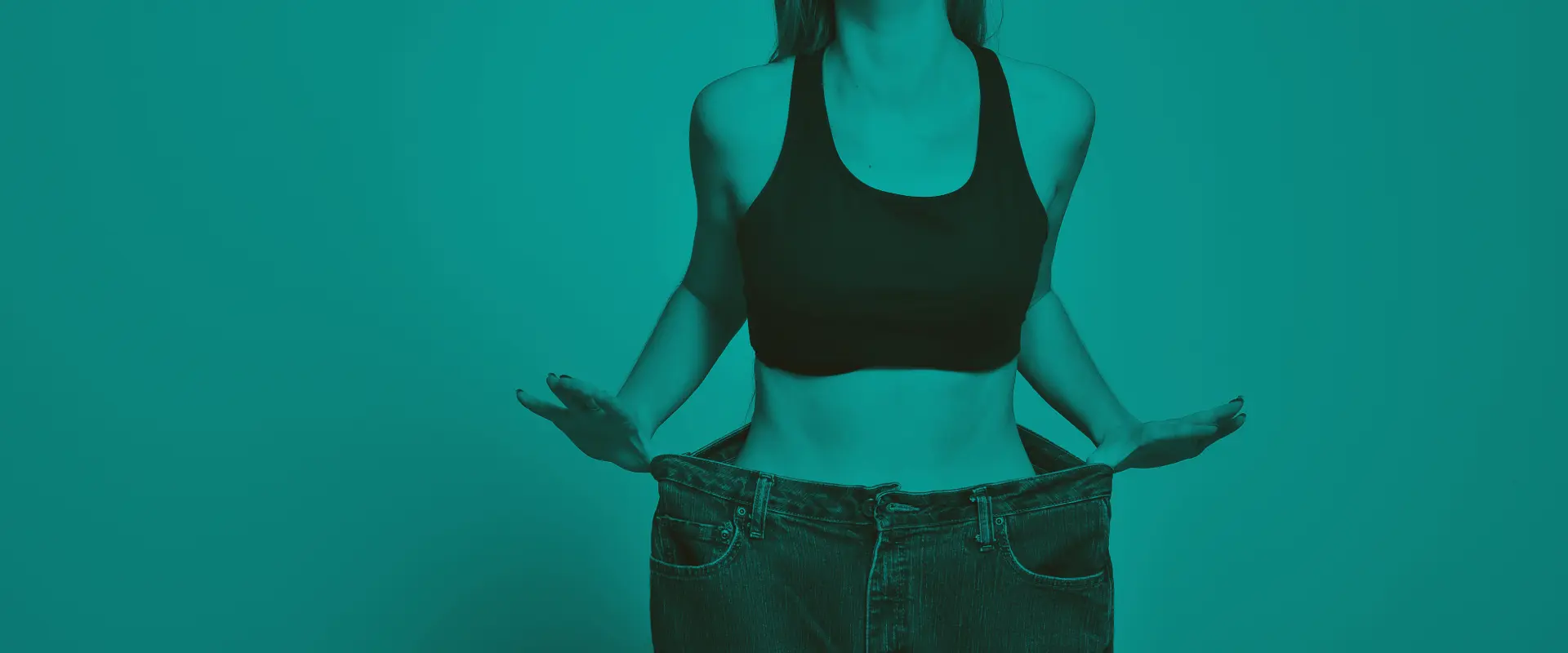 woman in her old jeans that are now too large after weight loss surgery