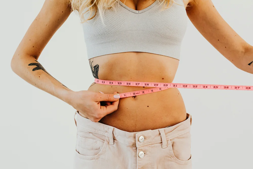 Woman measuring her waist after weight loss